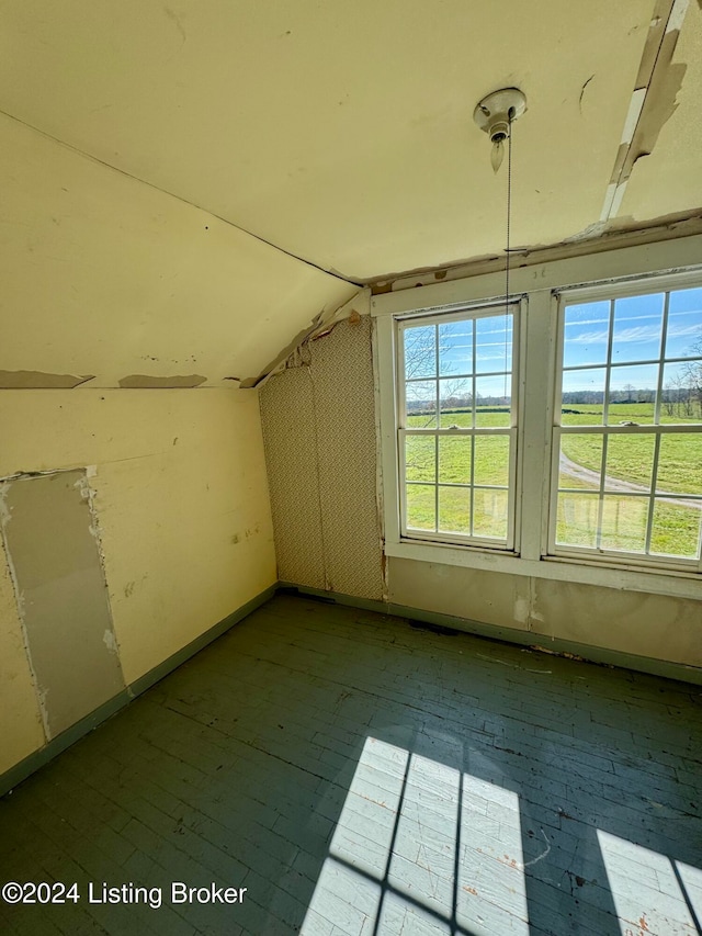 additional living space with light hardwood / wood-style flooring and lofted ceiling