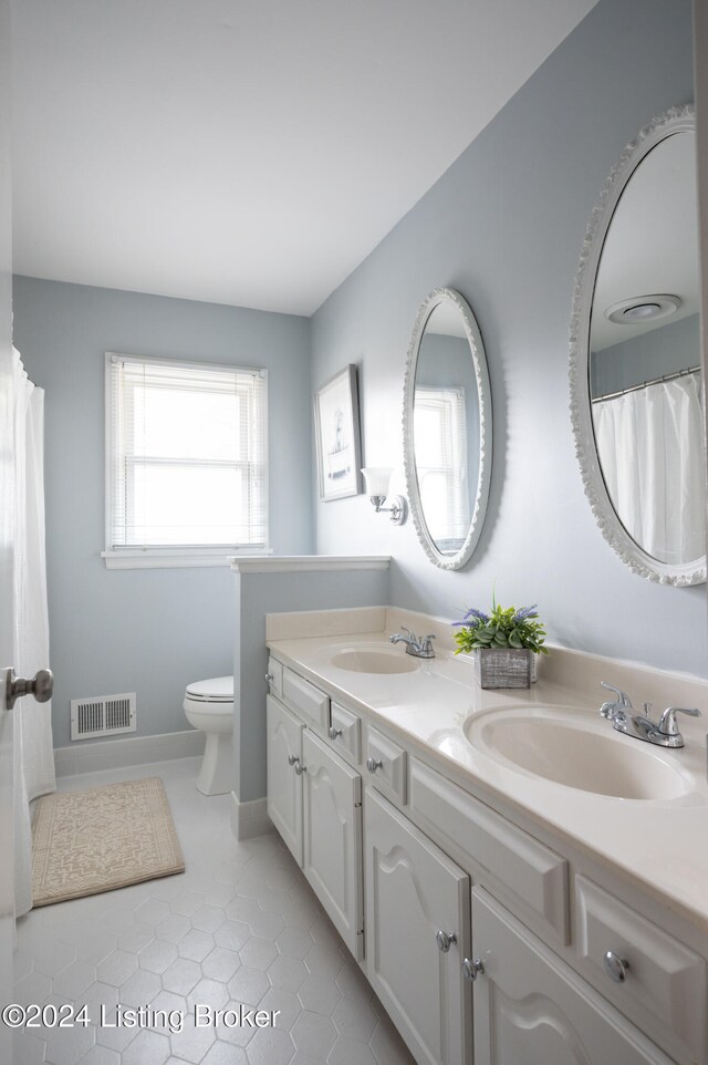 bathroom with vanity, toilet, and tile patterned flooring