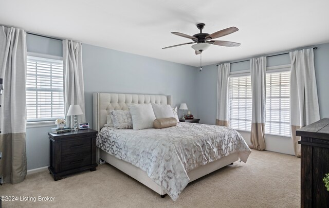 bedroom with ceiling fan and light carpet