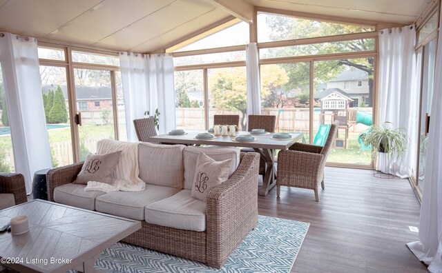 sunroom featuring plenty of natural light and vaulted ceiling with beams