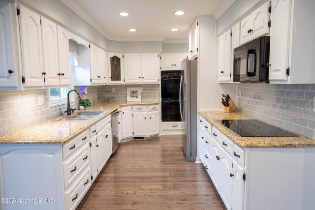 kitchen with sink, white cabinets, light stone counters, and black appliances