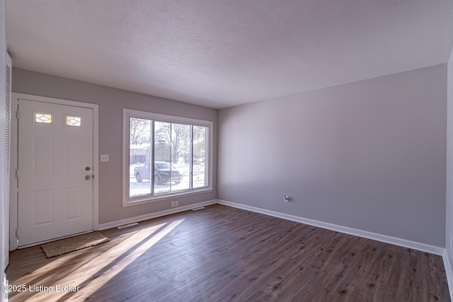 entryway featuring a textured ceiling and dark hardwood / wood-style flooring