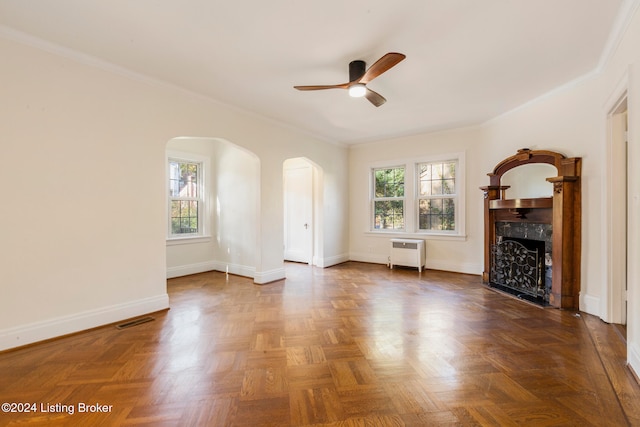 unfurnished living room featuring ornamental molding, dark parquet floors, heating unit, and ceiling fan