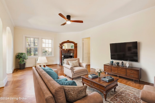 living room with parquet flooring, ceiling fan, and ornamental molding