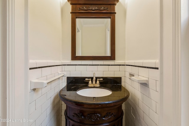 bathroom with vanity, ornamental molding, and tile walls