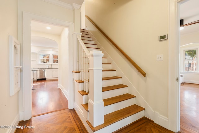 stairs with parquet flooring and sink