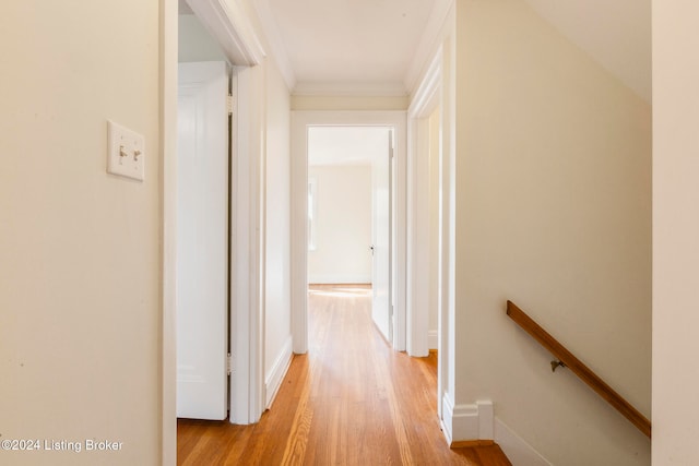 corridor featuring ornamental molding and light wood-type flooring