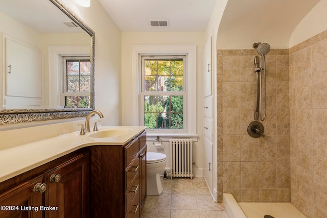 bathroom featuring tiled shower, tile patterned floors, toilet, vanity, and radiator heating unit