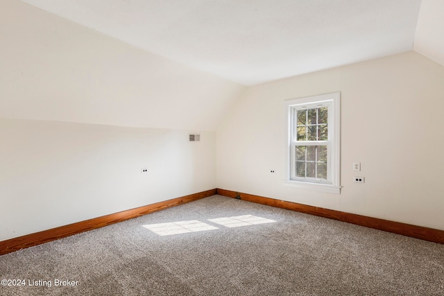 bonus room with carpet flooring and vaulted ceiling