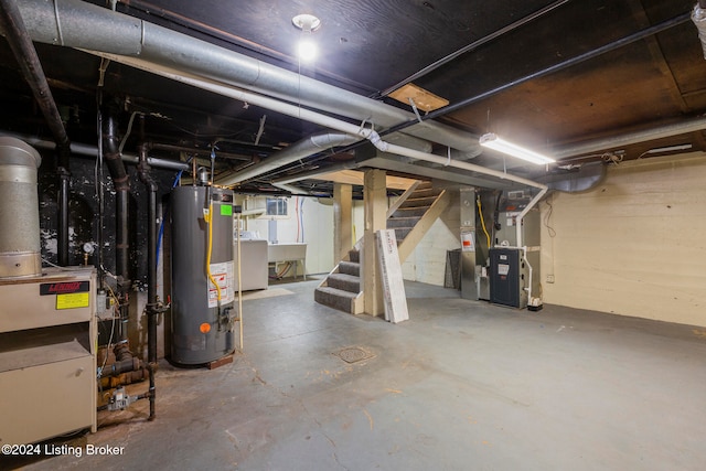 basement featuring washer / dryer, sink, heating unit, and gas water heater