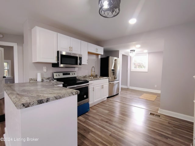 kitchen featuring kitchen peninsula, white cabinetry, light hardwood / wood-style flooring, sink, and stainless steel appliances