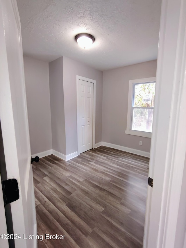 empty room featuring hardwood / wood-style flooring and a textured ceiling