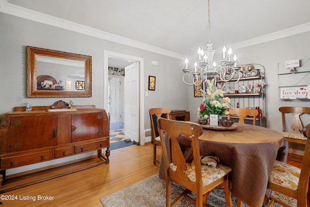 dining area with crown molding, a chandelier, and light wood-type flooring