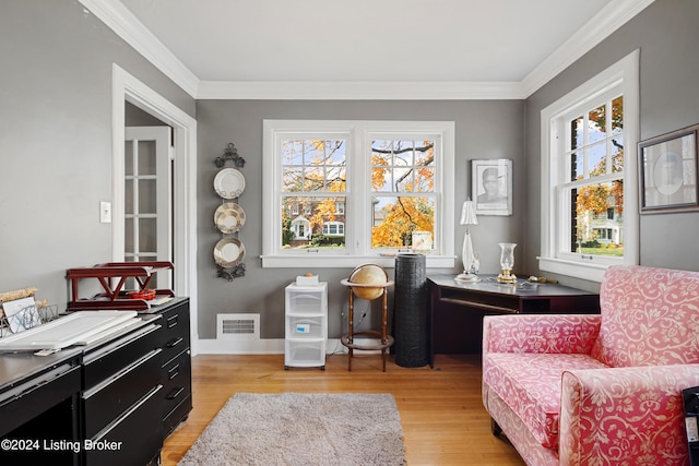 living area with crown molding and light wood-type flooring