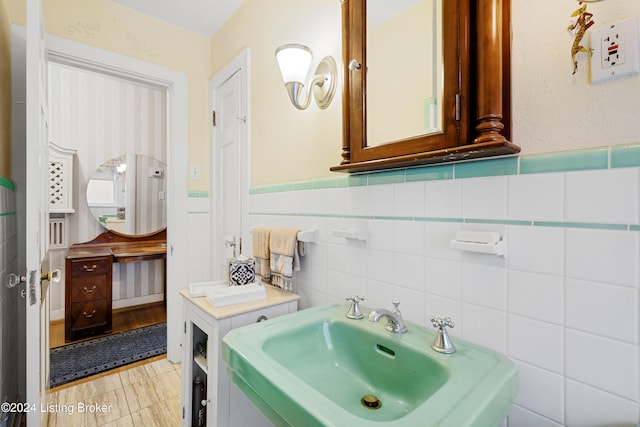 bathroom with sink and tile walls