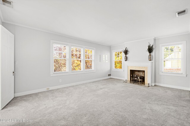 unfurnished living room featuring crown molding, carpet floors, and a tile fireplace