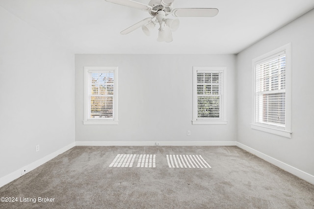 carpeted spare room with ceiling fan