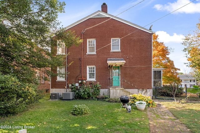 rear view of house featuring a yard and central AC unit