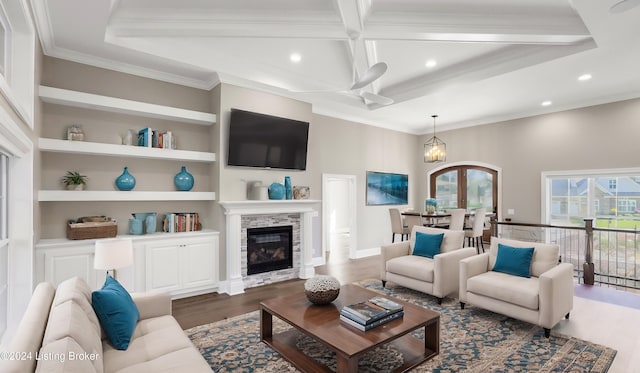 living room with built in features, ornamental molding, a fireplace, beamed ceiling, and dark hardwood / wood-style flooring