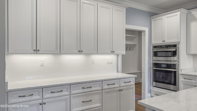 kitchen with double oven, white cabinetry, dark hardwood / wood-style flooring, and light stone countertops