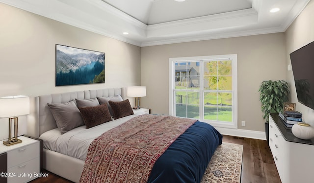 bedroom with ornamental molding, a raised ceiling, multiple windows, and dark wood-type flooring