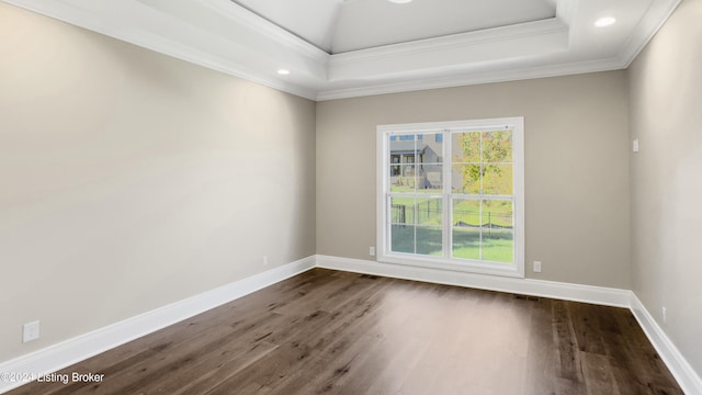 empty room with dark hardwood / wood-style floors, crown molding, and a tray ceiling