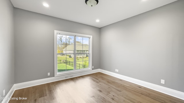 unfurnished room with hardwood / wood-style flooring