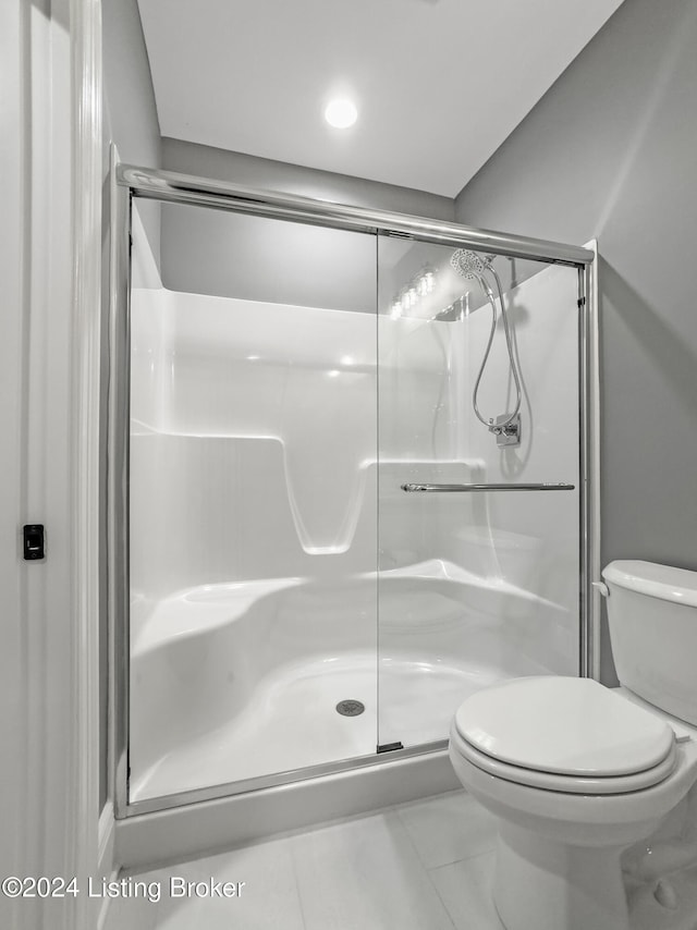 bathroom with an enclosed shower and toilet