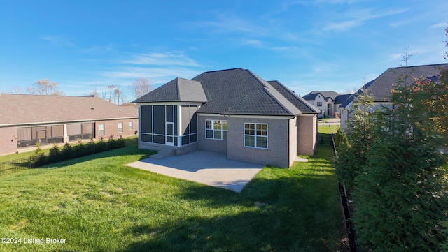 rear view of property featuring a lawn, a sunroom, and a patio