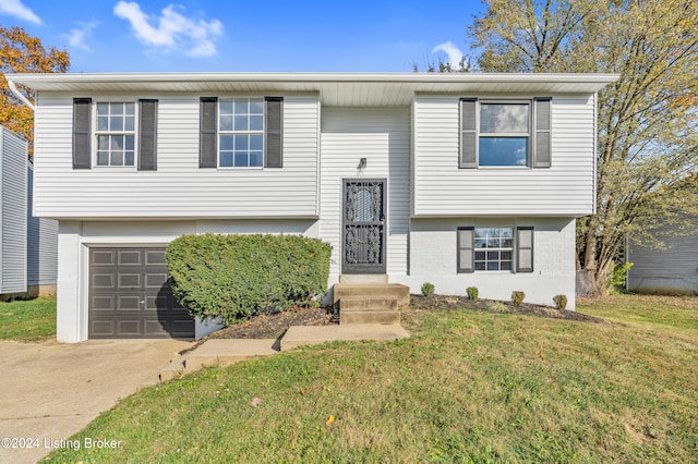 raised ranch with a garage and a front lawn