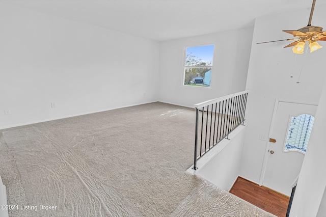 staircase with carpet and ceiling fan