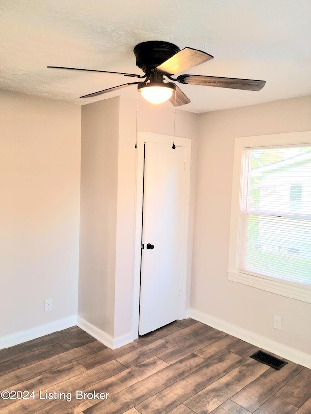 unfurnished room featuring ceiling fan, a textured ceiling, and dark hardwood / wood-style floors