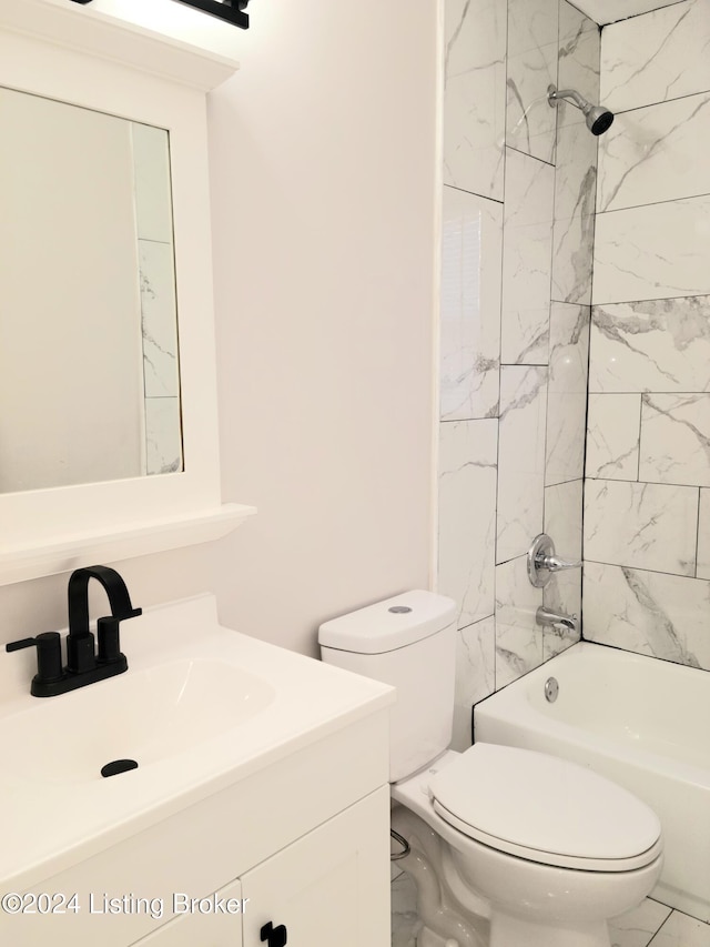 full bathroom featuring vanity, tiled shower / bath combo, and toilet