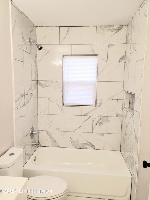 bathroom featuring toilet and tiled shower / bath combo