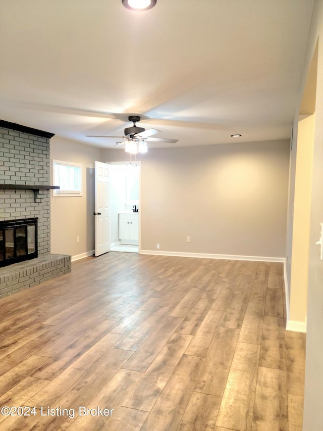 unfurnished living room featuring light hardwood / wood-style floors, a fireplace, and ceiling fan