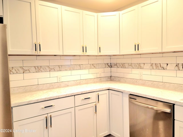 kitchen featuring white cabinetry, light stone counters, appliances with stainless steel finishes, and decorative backsplash