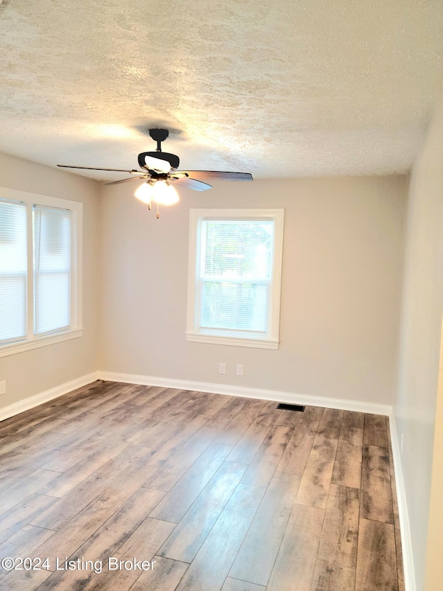 unfurnished room featuring hardwood / wood-style floors, a textured ceiling, and ceiling fan