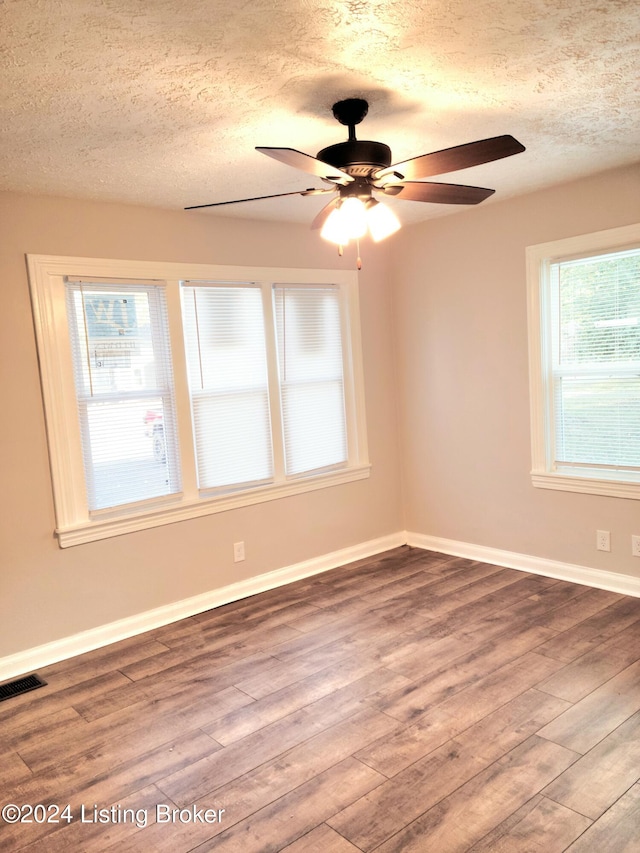 unfurnished room featuring hardwood / wood-style floors, a textured ceiling, and ceiling fan