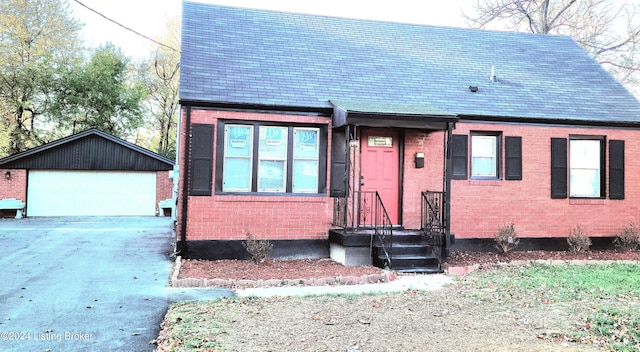 view of front of property with a garage and an outbuilding