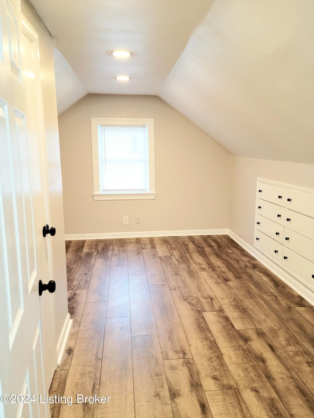 additional living space featuring hardwood / wood-style floors and vaulted ceiling