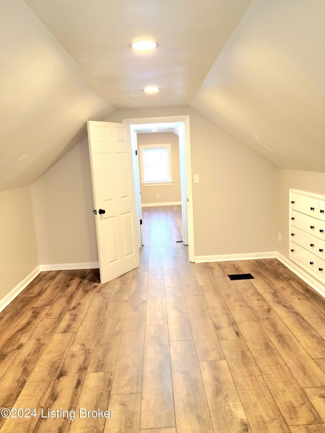 bonus room featuring lofted ceiling and light wood-type flooring