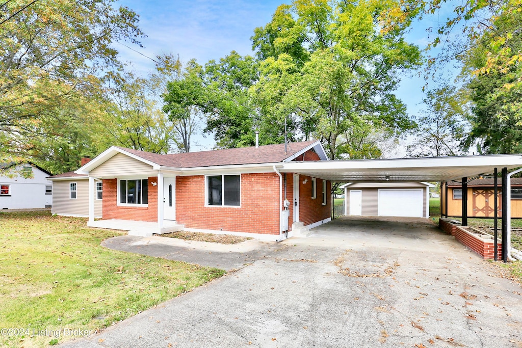 single story home with a front yard, an outbuilding, and a carport