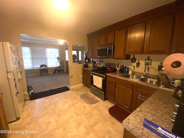 kitchen with stone countertops, sink, and appliances with stainless steel finishes