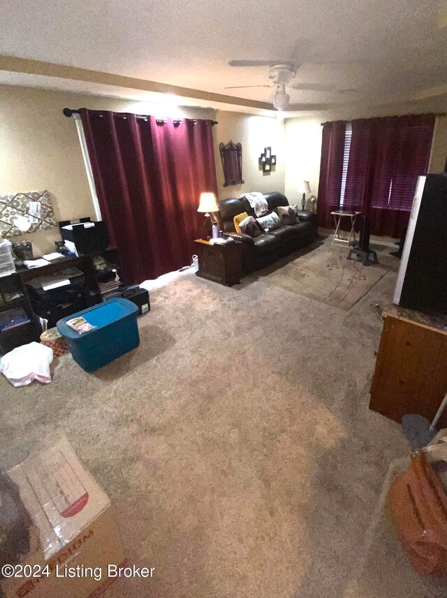 living room featuring ceiling fan, a textured ceiling, and carpet floors