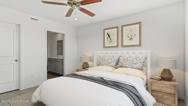 bedroom with sink, ceiling fan, hardwood / wood-style flooring, and ensuite bath