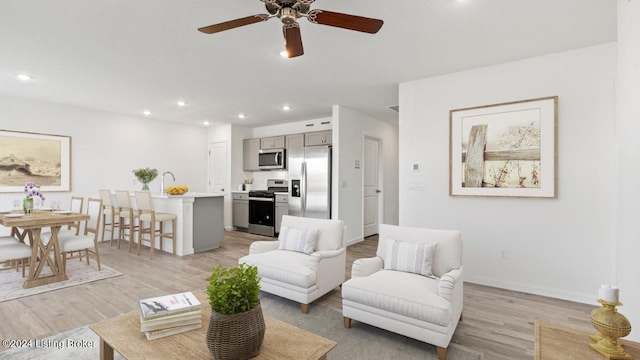 living room with light wood-type flooring and ceiling fan