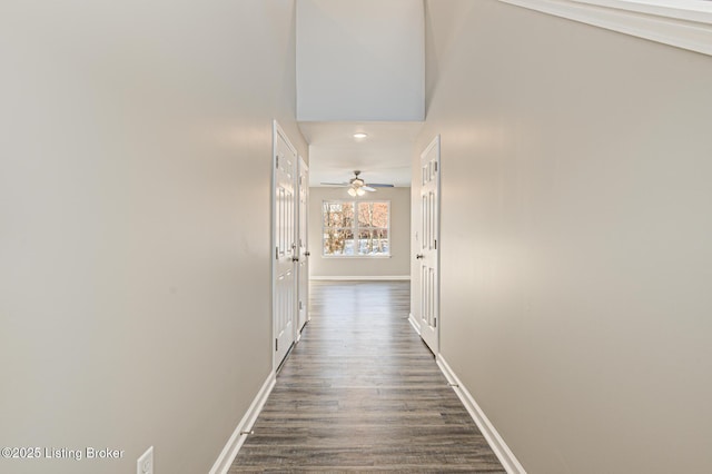 hall with a towering ceiling and dark hardwood / wood-style floors