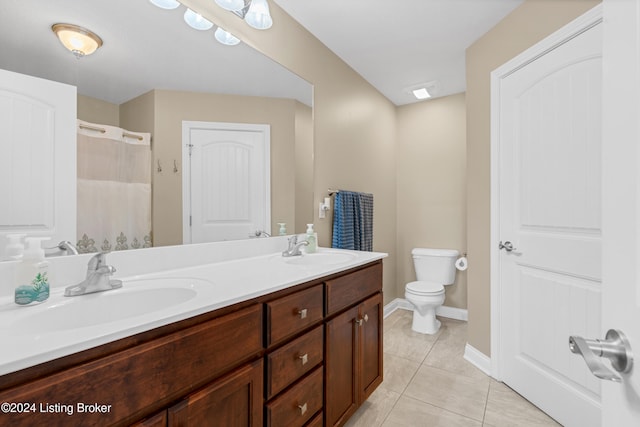 bathroom with vanity, toilet, curtained shower, and tile patterned flooring