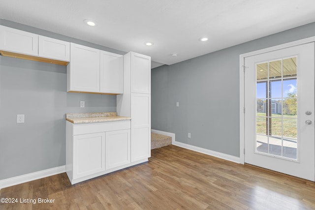 kitchen with light hardwood / wood-style flooring and white cabinets