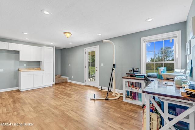 home office with a wealth of natural light and light hardwood / wood-style flooring